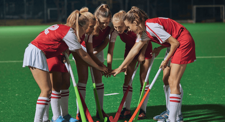 Team of field hockey players in a huddle