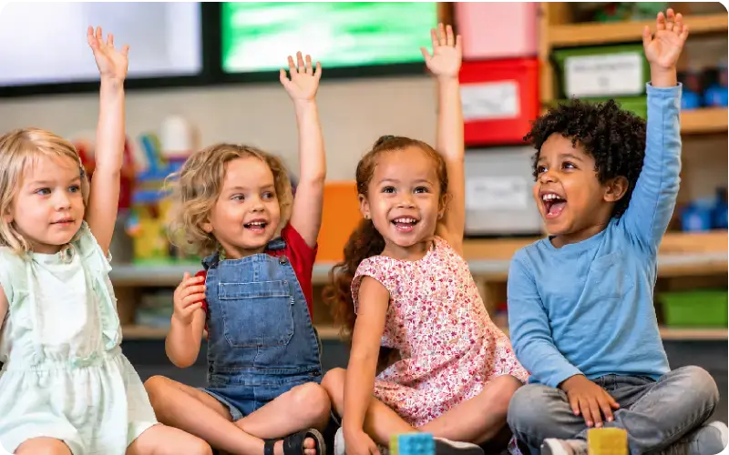 preschool kids raising hands