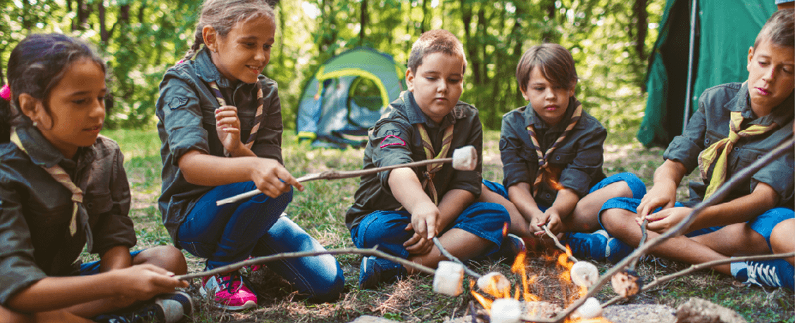 Scout troop roasting marshmallows at a campfire